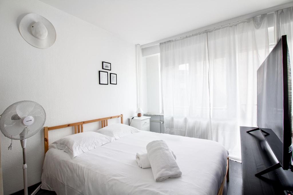 a bedroom with a bed with white sheets and a window at Sweet-Neipperg in Luxembourg
