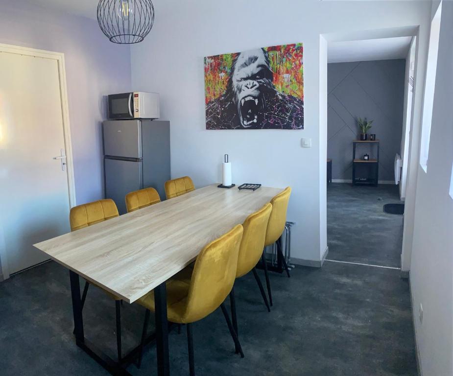 una sala da pranzo con tavolo in legno e sedie gialle di À louer, charmante maison à Douai a Douai