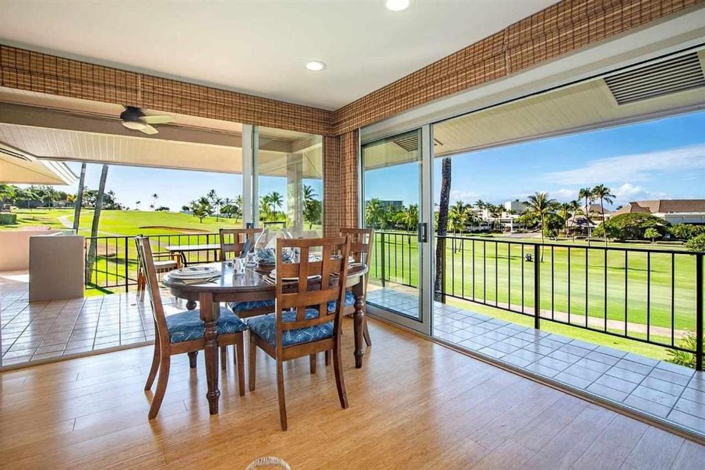 a dining room with a table and chairs and a balcony at Maui Eldorado Condo G206 in Kaanapali