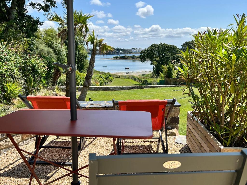 d'une table et de chaises avec vue sur le lac. dans l'établissement T2 Etelria les pieds dans l'eau, à Plouhinec