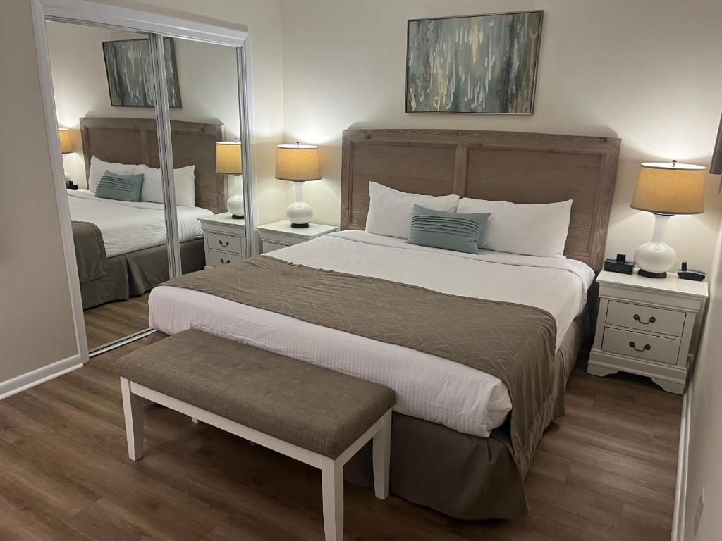 Un dormitorio con una cama grande y un espejo. en Summer Sands - 202 by Sea Scape Properties, en Wrightsville Beach