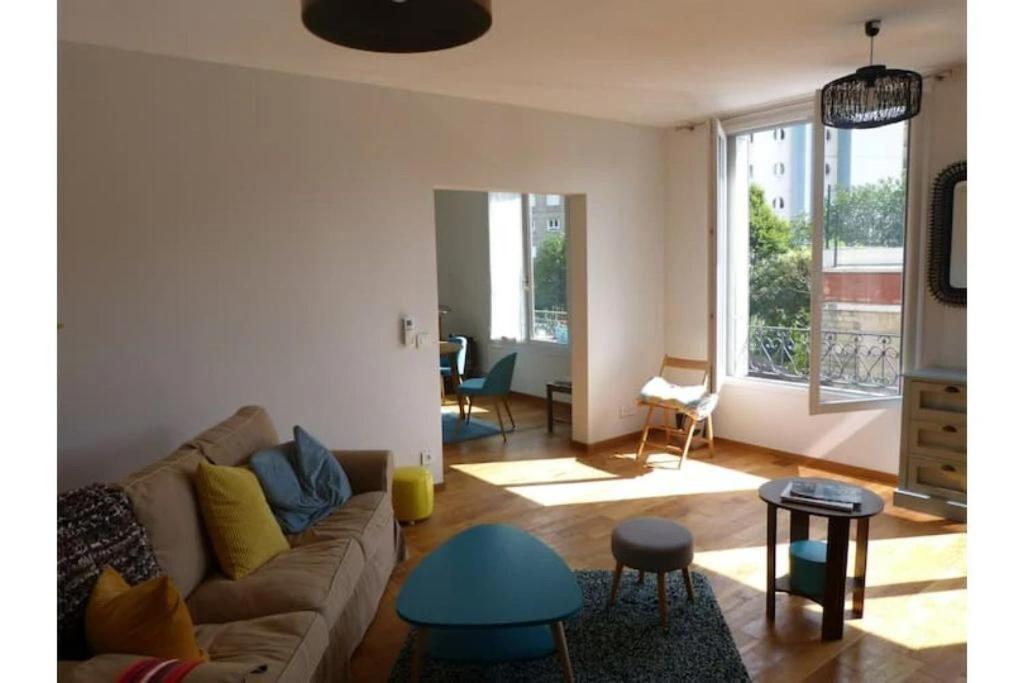 a living room with a couch and a table at Agréable Maison Familiale in Arcueil