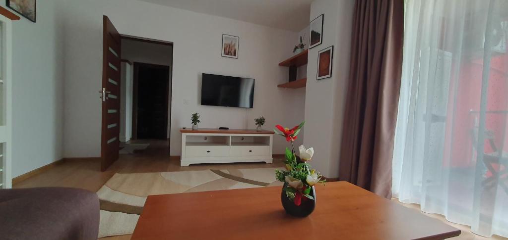 a living room with a vase with flowers on a table at Apartament Relaxa Green 3 - 2 Rooms - AC - Parking in Târgu-Mureş