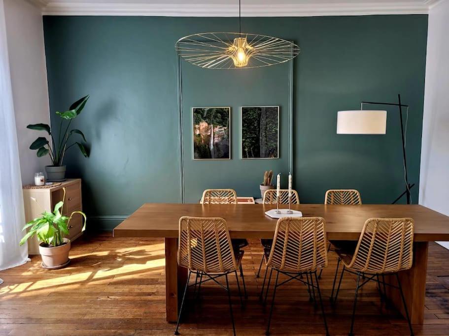 une salle à manger avec une table et des chaises en bois dans l'établissement Le Botanik - Haussmannien près jardin des plantes, à Nantes