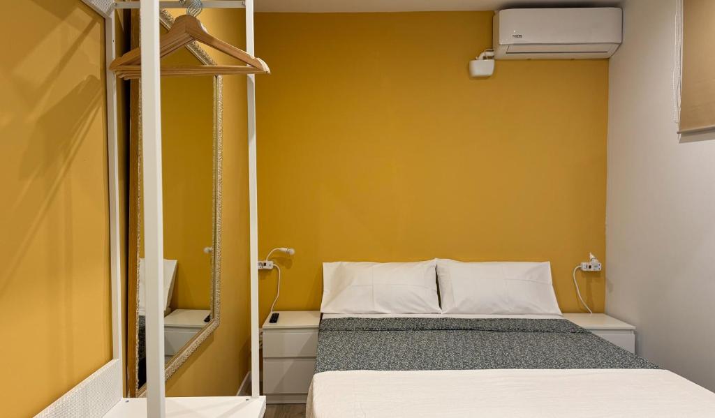 a small bed in a room with a yellow wall at Hostal Oliveta Budget in Barcelona