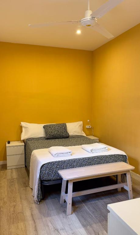 a bedroom with a bed with a yellow wall at Hostal Oliveta Budget in Barcelona