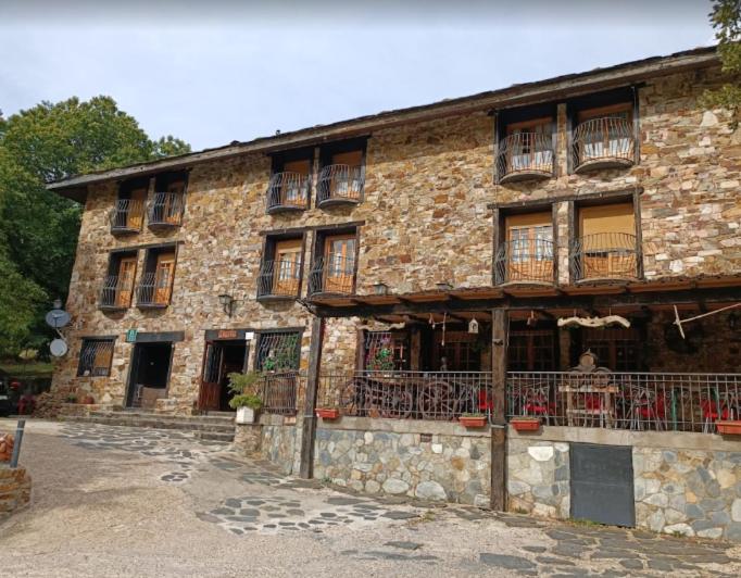 un gran edificio de ladrillo con mesas y sillas. en Posada El Rincón de Valverde, en Valverde de los Arroyos