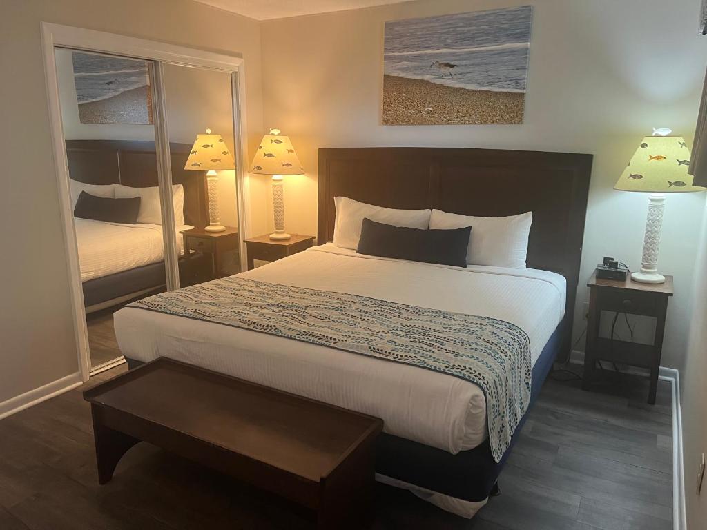 a bedroom with a large bed and a mirror at Summer Sands - 304 by Sea Scape Properties in Wrightsville Beach