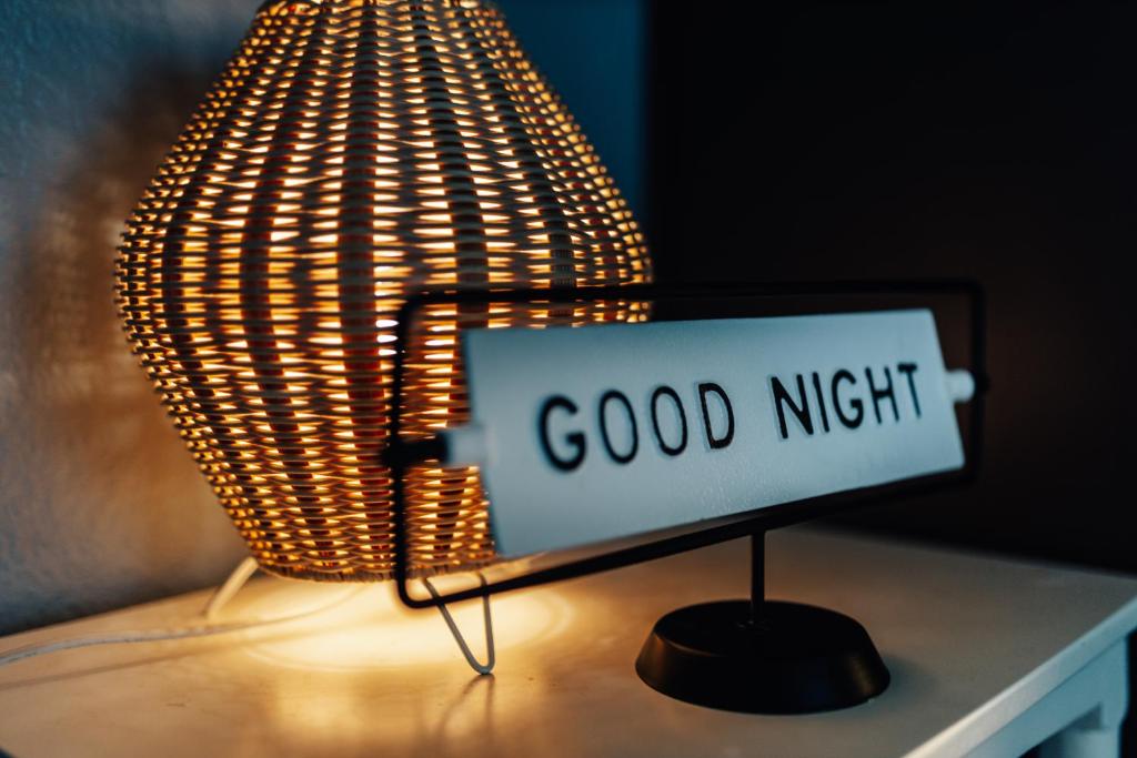 un panneau de bonne nuit sur une table à côté d'une lampe dans l'établissement Holiday Pool Retreat by Downtown- Lake & Dining Just Steps Away, à Austin