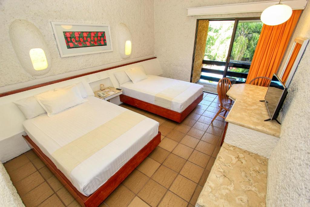 Postel nebo postele na pokoji v ubytování Hotel Ciudad Real Palenque