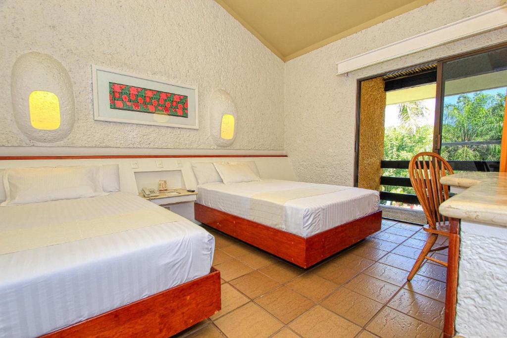 Postel nebo postele na pokoji v ubytování Hotel Ciudad Real Palenque