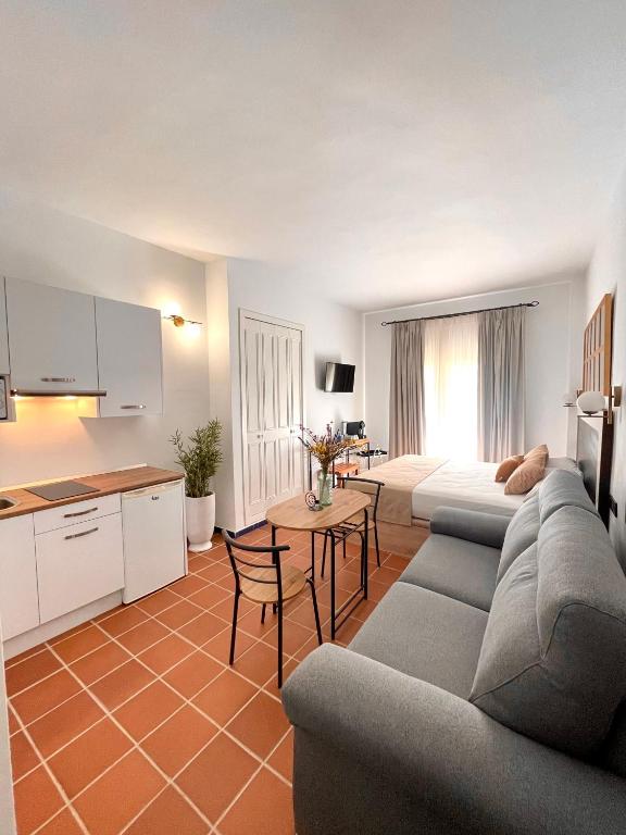 a living room with a couch and a table and a kitchen at Piropos de Doñana in El Rocío