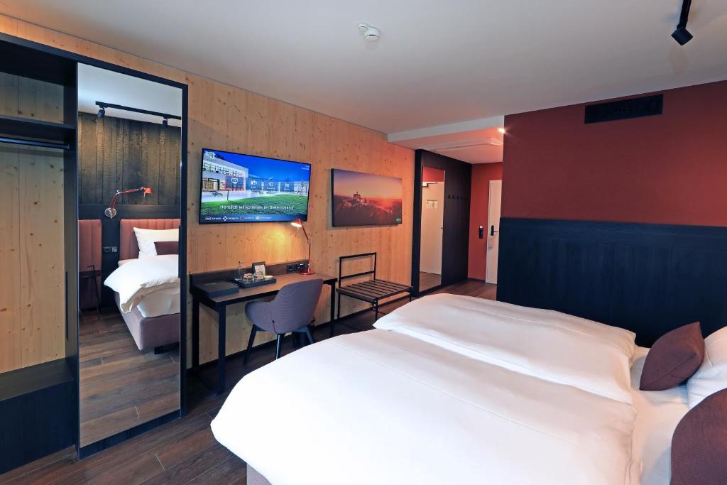 Postel nebo postele na pokoji v ubytování Hotel Steiermarkhof Graz - Aus Holz gebaut, von Hügeln geküsst