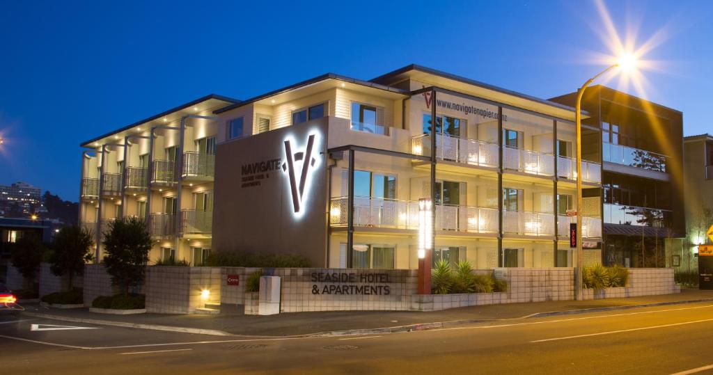 un edificio con una señal delante de él en Navigate Seaside Hotel & Apartments, en Napier