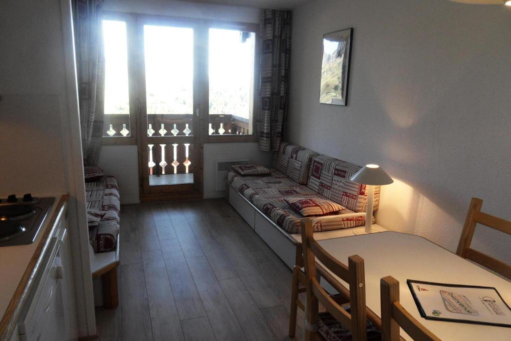 un salon avec un canapé et une table dans l'établissement Résidence Licorne - Studio pour 4 Personnes 99, à Mâcot La Plagne