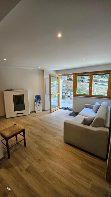 a living room with a couch and a tv at Appartement Chalet - 1 chambre lit double - espace partagé in Briançon