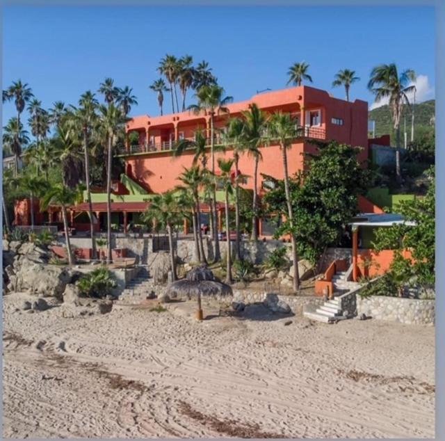 a large red building with palm trees in front of it at Agave Hotel Club in Buenavista