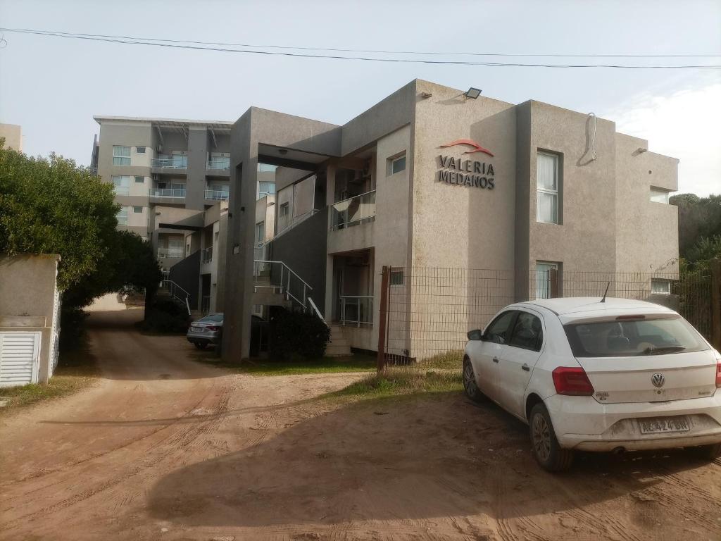 a white car parked in front of a building at Valeria Medanos in Valeria del Mar