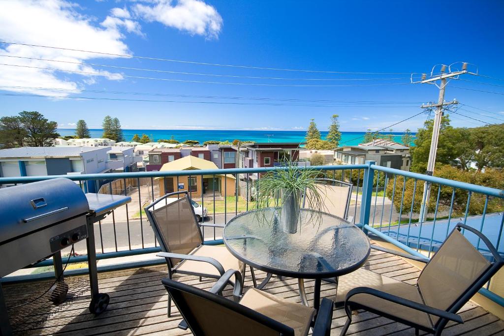 a balcony with a table and chairs and the ocean at Lorne Ocean Sun Apartments in Lorne