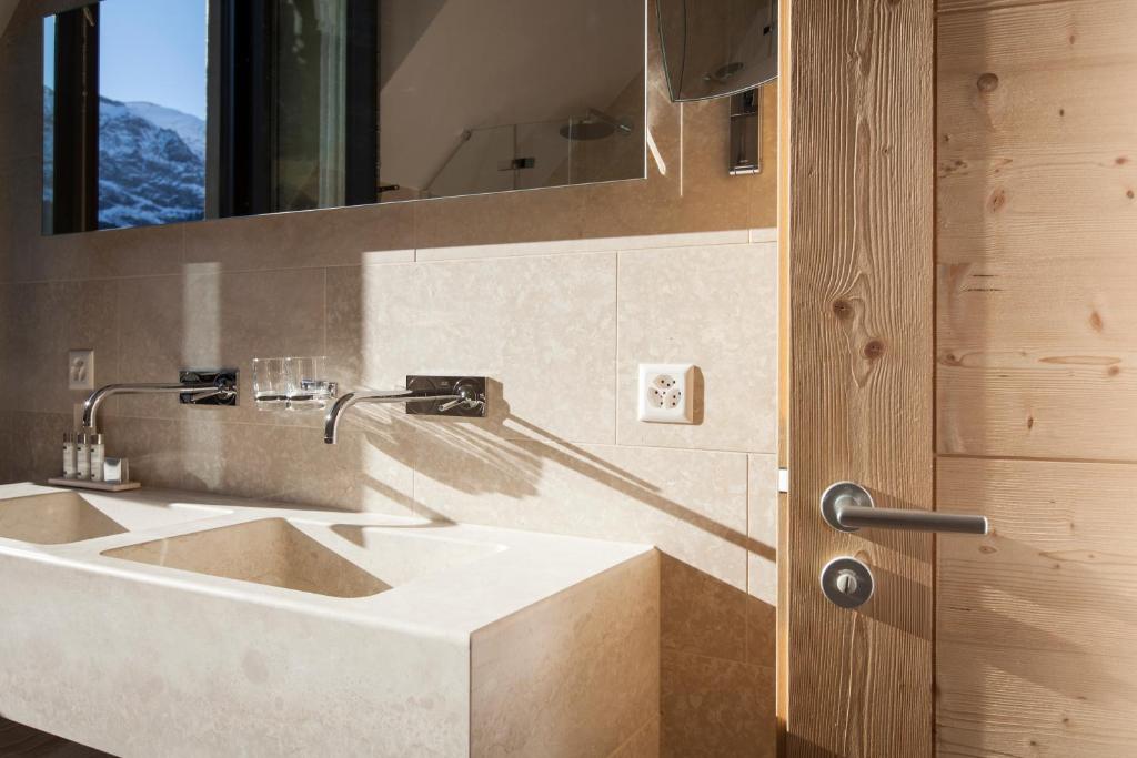a bathroom with a sink and a mirror at Hôtel National Resort & Spa in Champéry