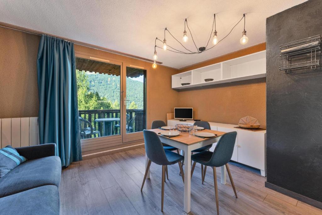 une cuisine et un salon avec une table et des chaises dans l'établissement Résidence Le MÉale - Studio rénové 4 personnes aux Orres 1650 MAE-9341, aux Orres