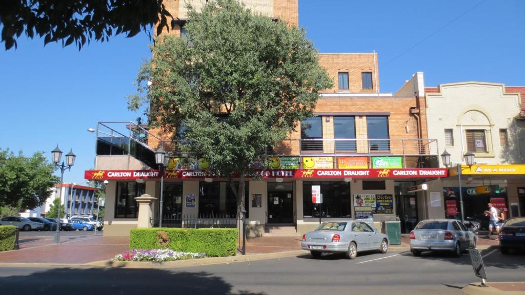 Amaroo Hotel Dubbo في دوبو: شارع المدينة فيه سيارات تقف امام مبنى