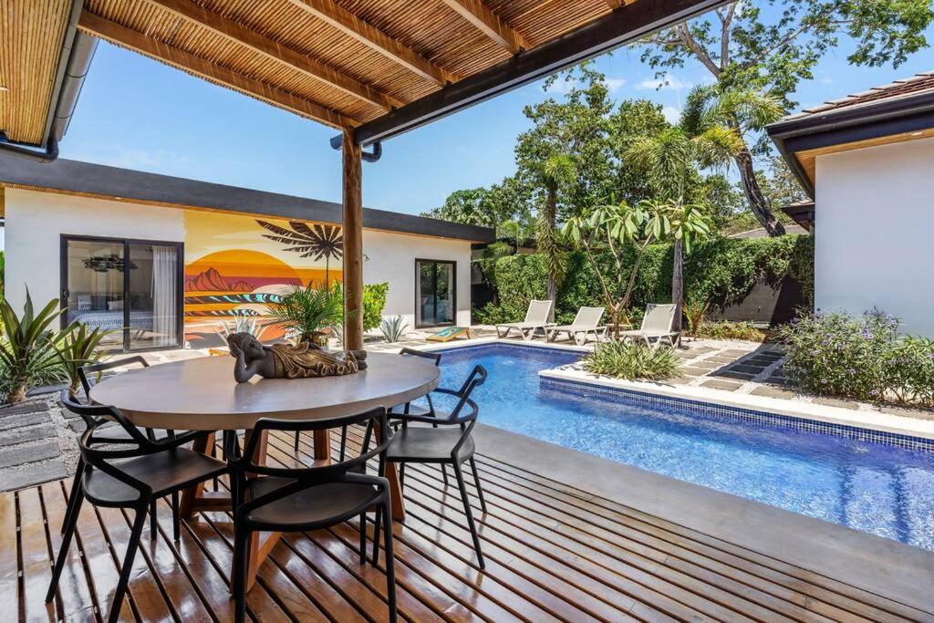 a patio with a table and chairs next to a swimming pool at CU15 New Modern Home with Casitas and Private Pool in Tamarindo