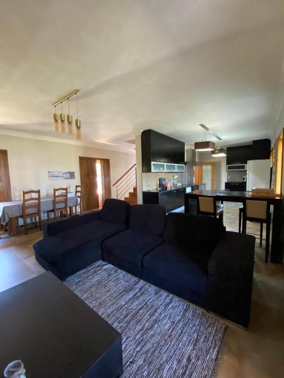 een woonkamer met een blauwe bank en een keuken bij Cantinho do Minho - Ponte de Lima in Ponte de Lima