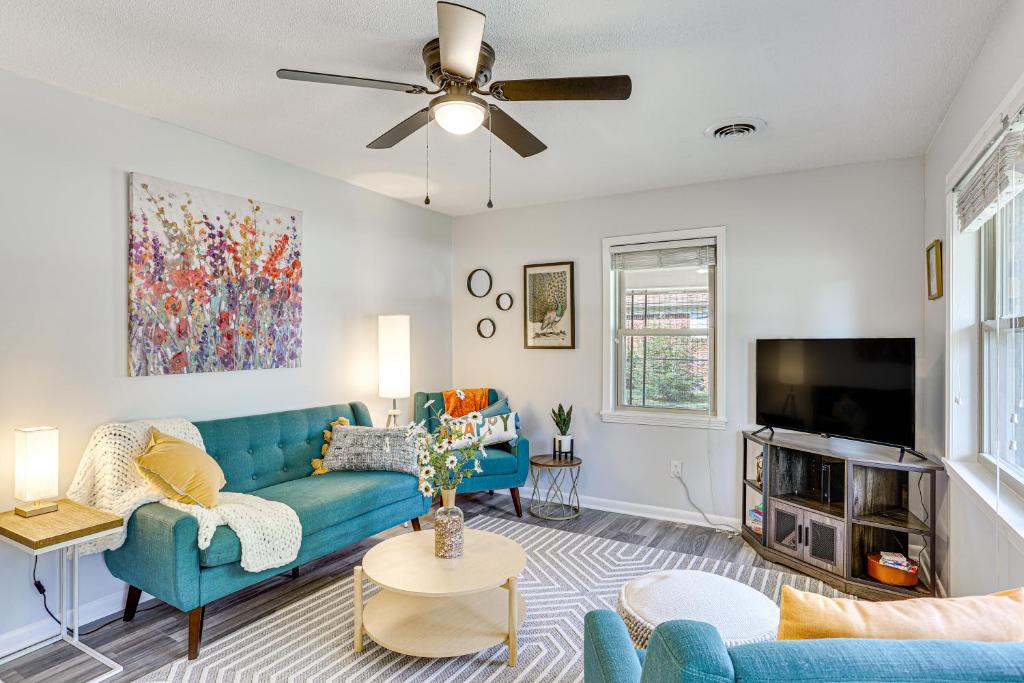 een woonkamer met een blauwe bank en een tv bij Dandys Getaway with Fire Pit and Yard in Henderson in Henderson