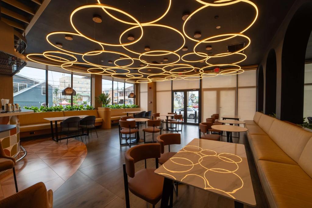 un restaurante con una gran lámpara de araña dorada en Aiden by Best Western Georgetown Guyana, en Georgetown