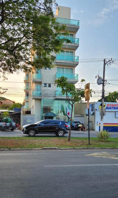 a blue car parked in front of a building at Flats Paris in Lagoa Santa