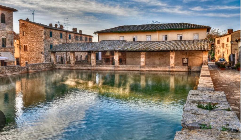 une vue d'une rivière dans une ville avec des bâtiments dans l'établissement Maison Amiata, à Montelaterone
