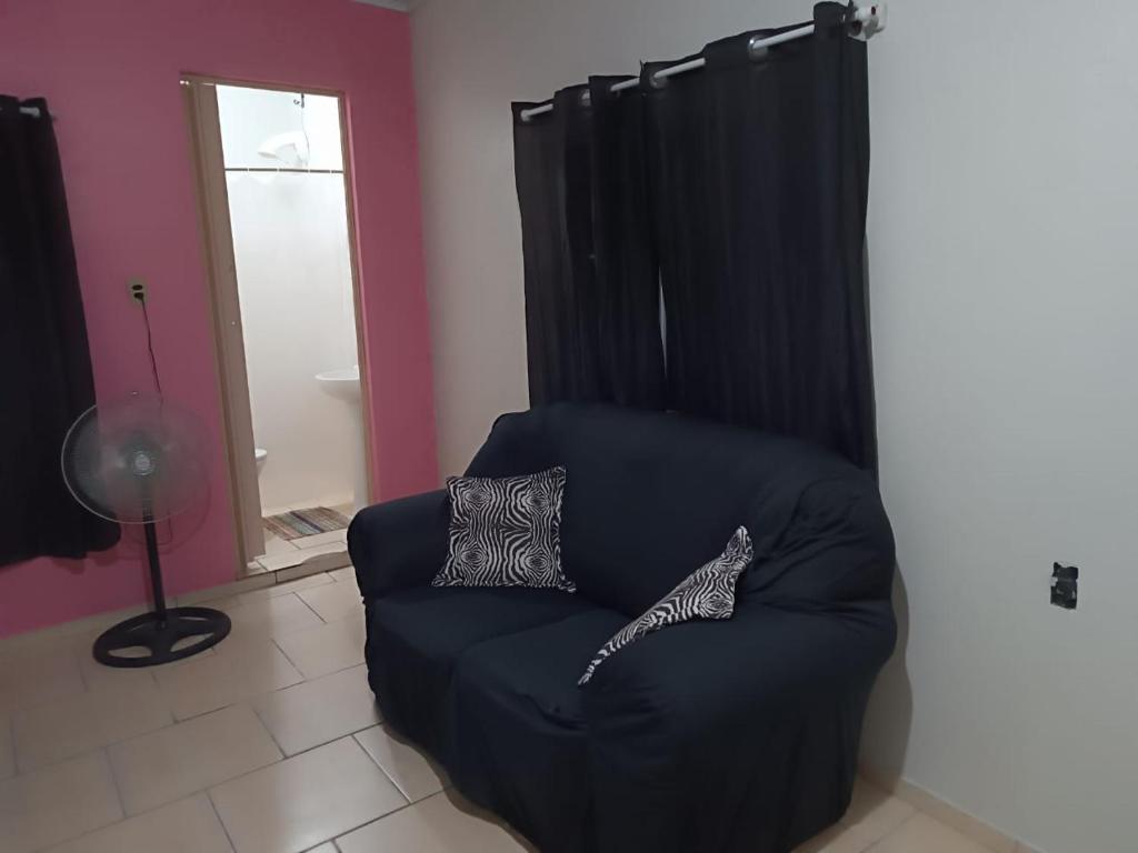a black chair with two pillows on it in a room at Pousada Paradise in Rio Grande