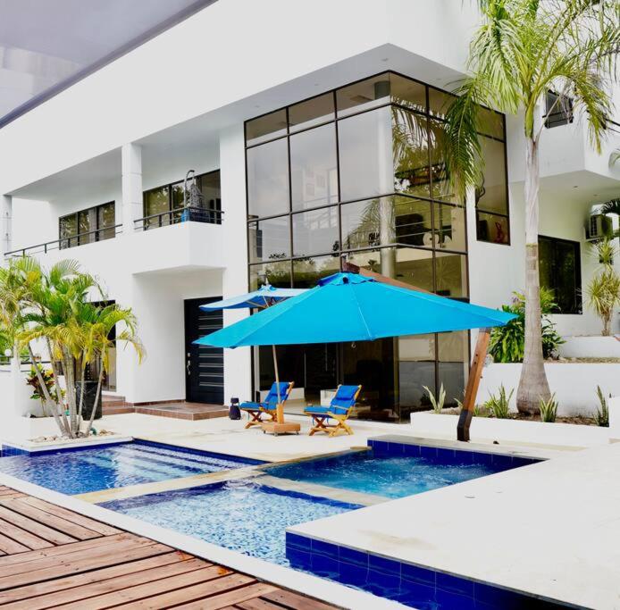 a house with a swimming pool with a blue umbrella at Villa in Guaduala