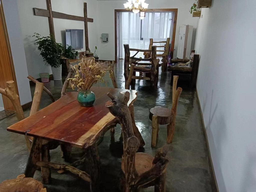 Un comedor con mesa y sillas de madera. en Yijia Xiaozhu, en Hanqiyu
