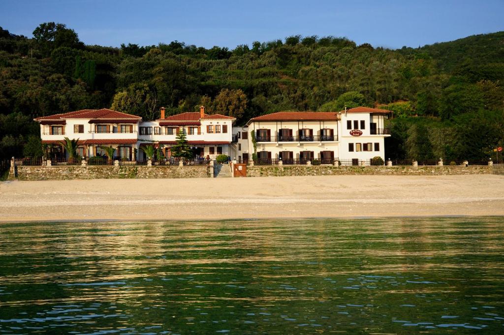 a group of houses on the beach next to the water at Hotel Hagiati in Chorefto