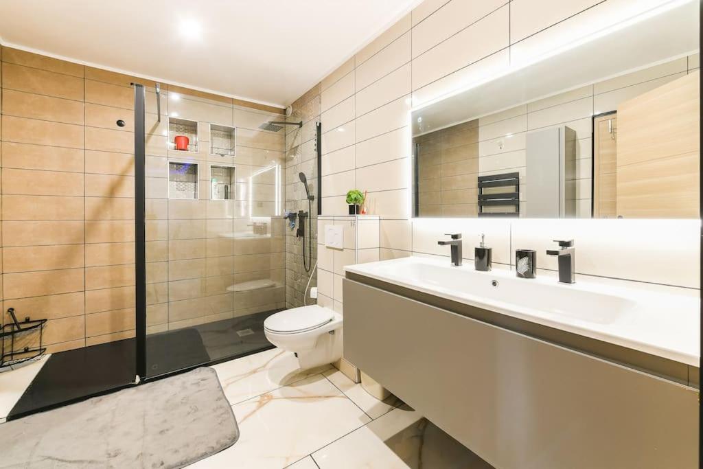 une salle de bain avec toilettes, lavabo et douche dans l'établissement L'Elégante Etoile Parisienne avec Terrasse - Proche Gare et Seine, aux Mureaux