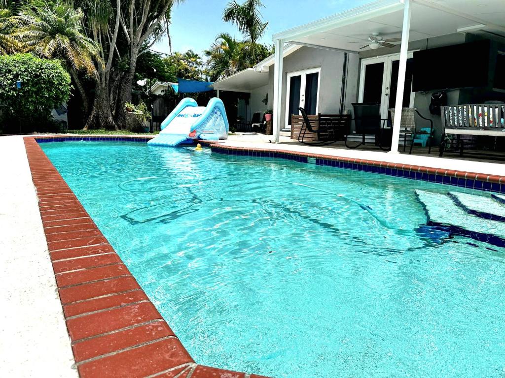 a swimming pool with a slide in a house at Pool House Resort heated swimming pool family getaway in Cutler Bay