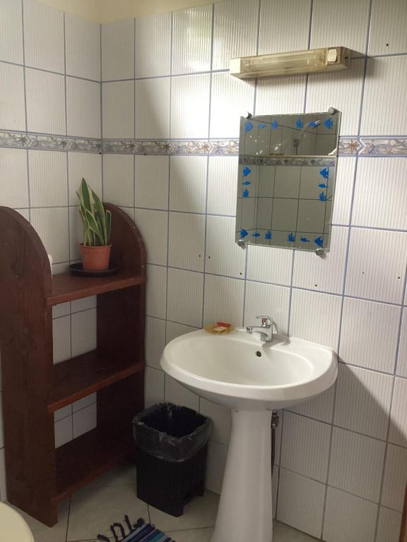 un bagno con lavandino e specchio di Chambre chez Kim a Taputapuapea