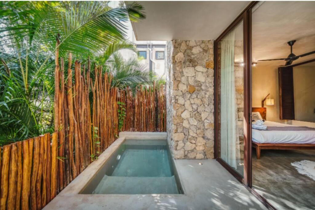 トゥルムにある2BR Condo Plunge Pool in Tulumのベッドルームの隣にスイミングプールがあります。