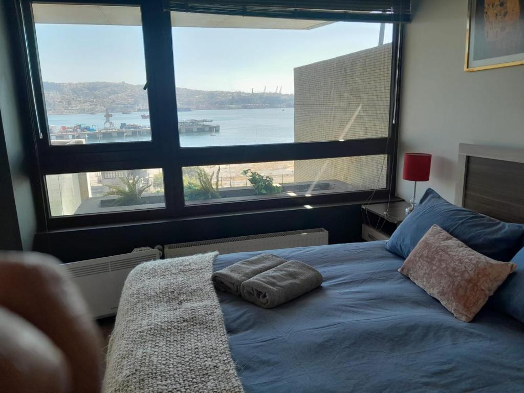 une chambre avec un lit avec une grande fenêtre dans l'établissement HOM I Espectacular depto 2D2B para 4PAX frente al Mar 0302, à Valparaíso