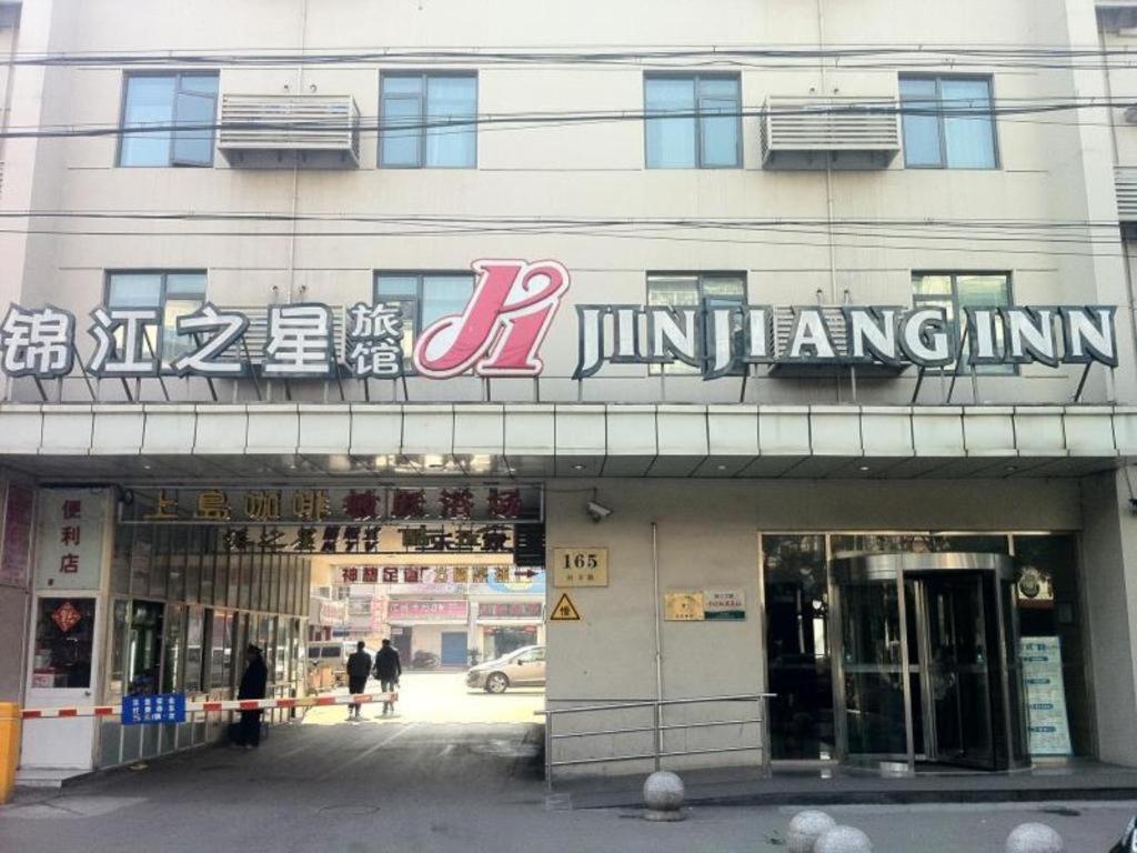 a building with a sign on the front of it at Magnotel Business Shanghai Minhang Wujing East China Normal University in Shanghai