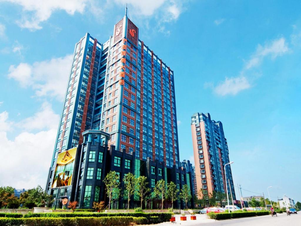a large building with two tall buildings at Ningbo ShouNan Hotel in Ningbo