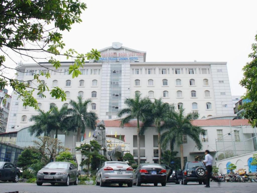 a large white building with cars parked in front of it at Cong Doan Viet Nam Hotel in Hanoi