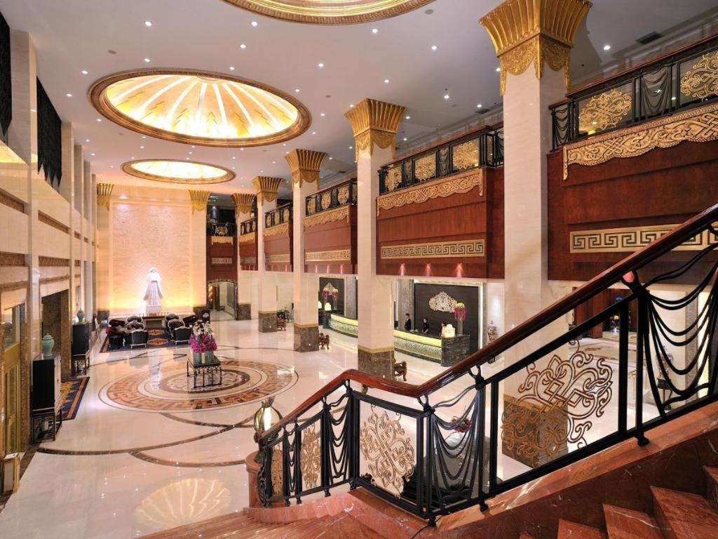 a large lobby with a staircase in a building at Hohhot Inner Mongolia Hotel in Hohhot