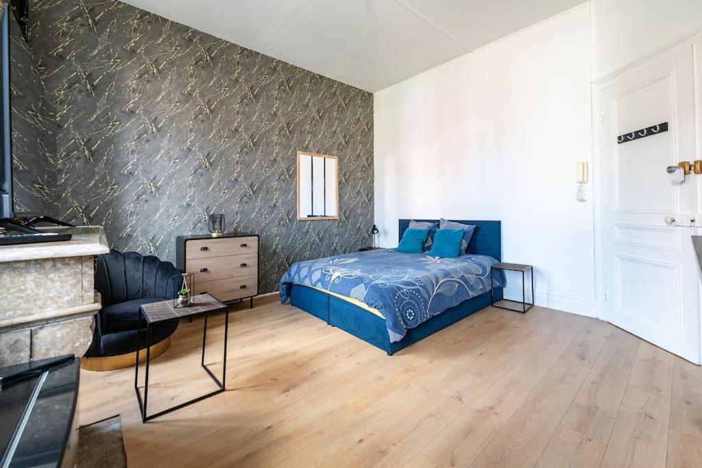 une chambre avec un lit et une table dans une pièce dans l'établissement Les Appart'Hôtels Du Calaisis - 102 Shadow, à Calais