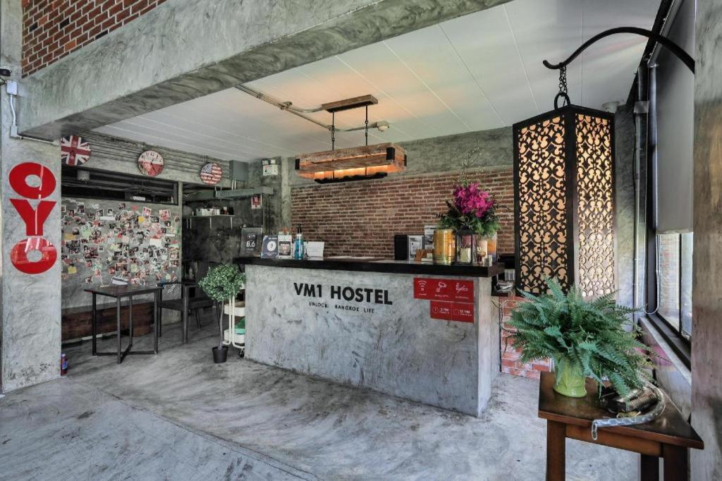 a restaurant with a counter in a room at Vm1 Hostel in Bangkok
