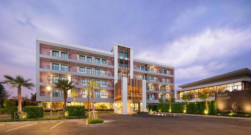 a large building with a parking lot in front of it at The Canal 304 in Si Maha Phot