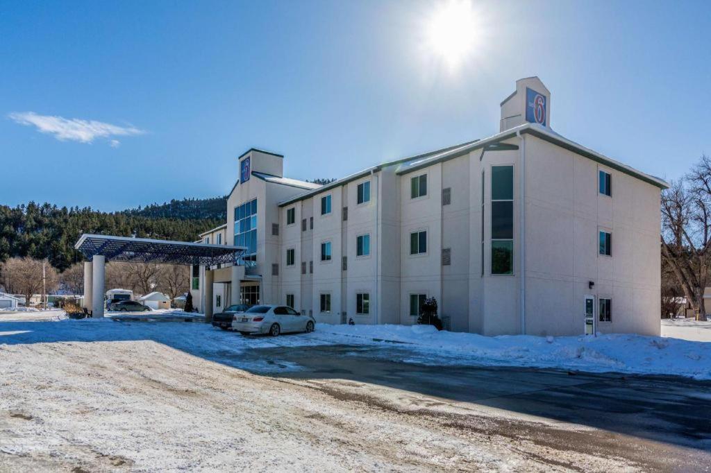 un gran edificio blanco con un coche aparcado en un aparcamiento en Econo Lodge Hot Springs South, en Hot Springs