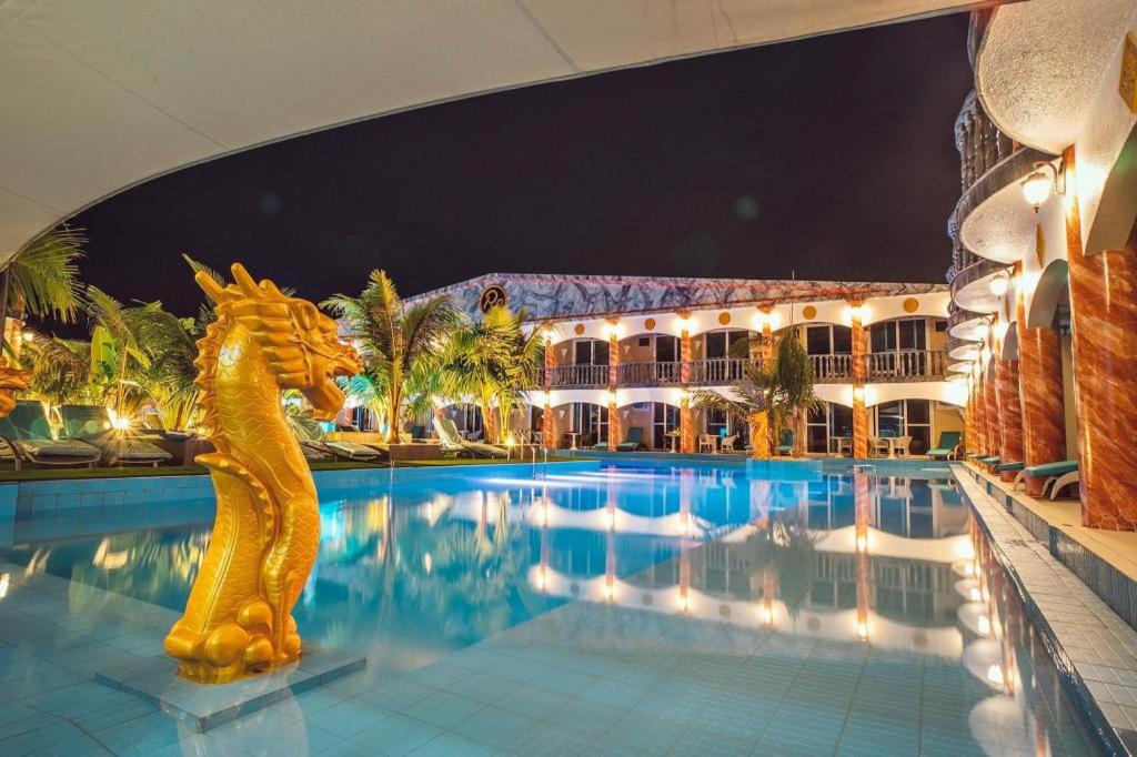 a hotel swimming pool at night with a dragon statue at Roman Empire Panglao Boutique Resort in Bohol-Panglao International Airport